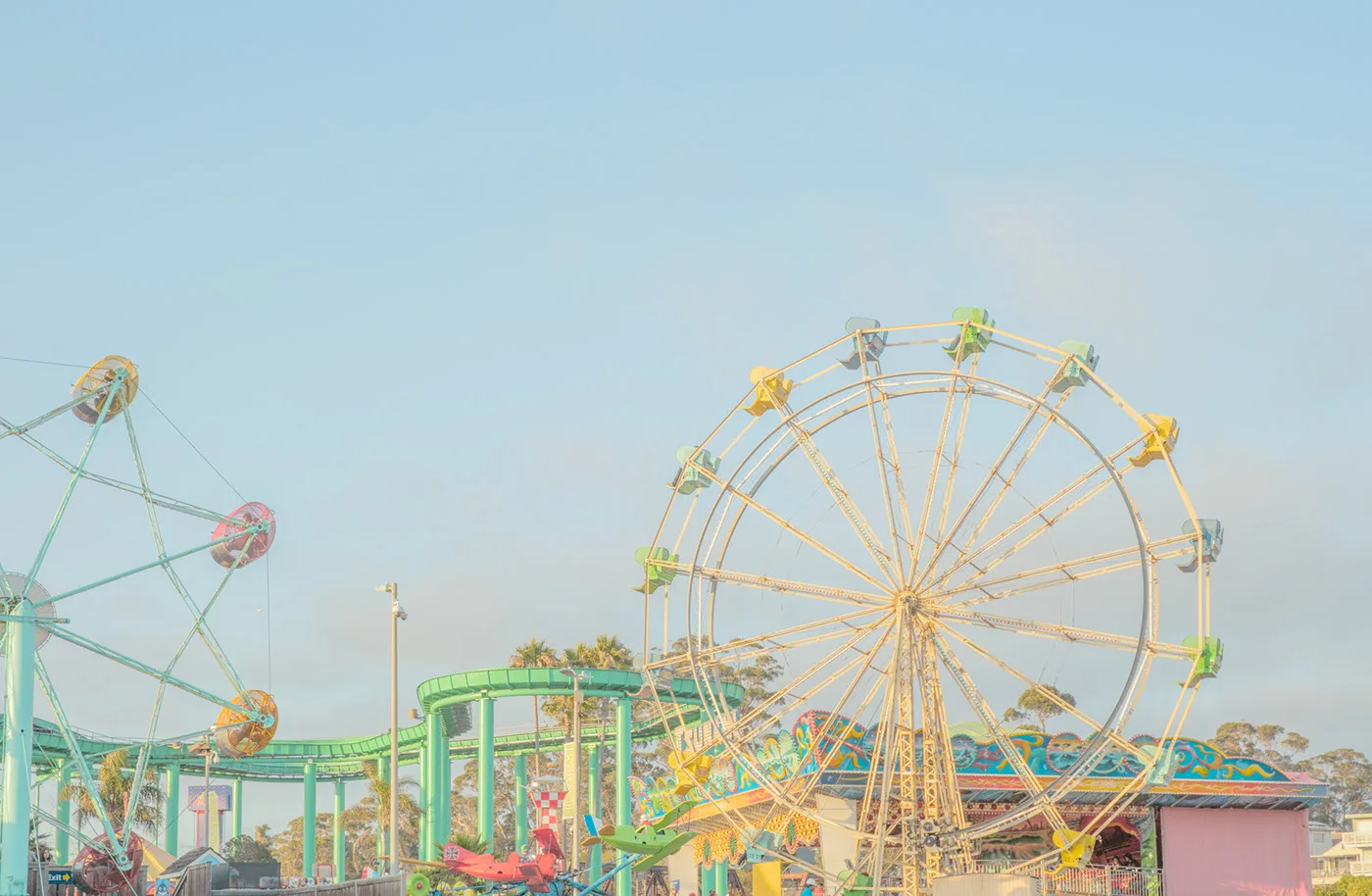 Colorful amusement park with Ferris wheel and roller coaster in warm light — limited edition fine art print by Ludwig Favre Colorful amusement park with Ferris wheel and roller coaster in warm light — limited edition fine art print by Ludwig Favre