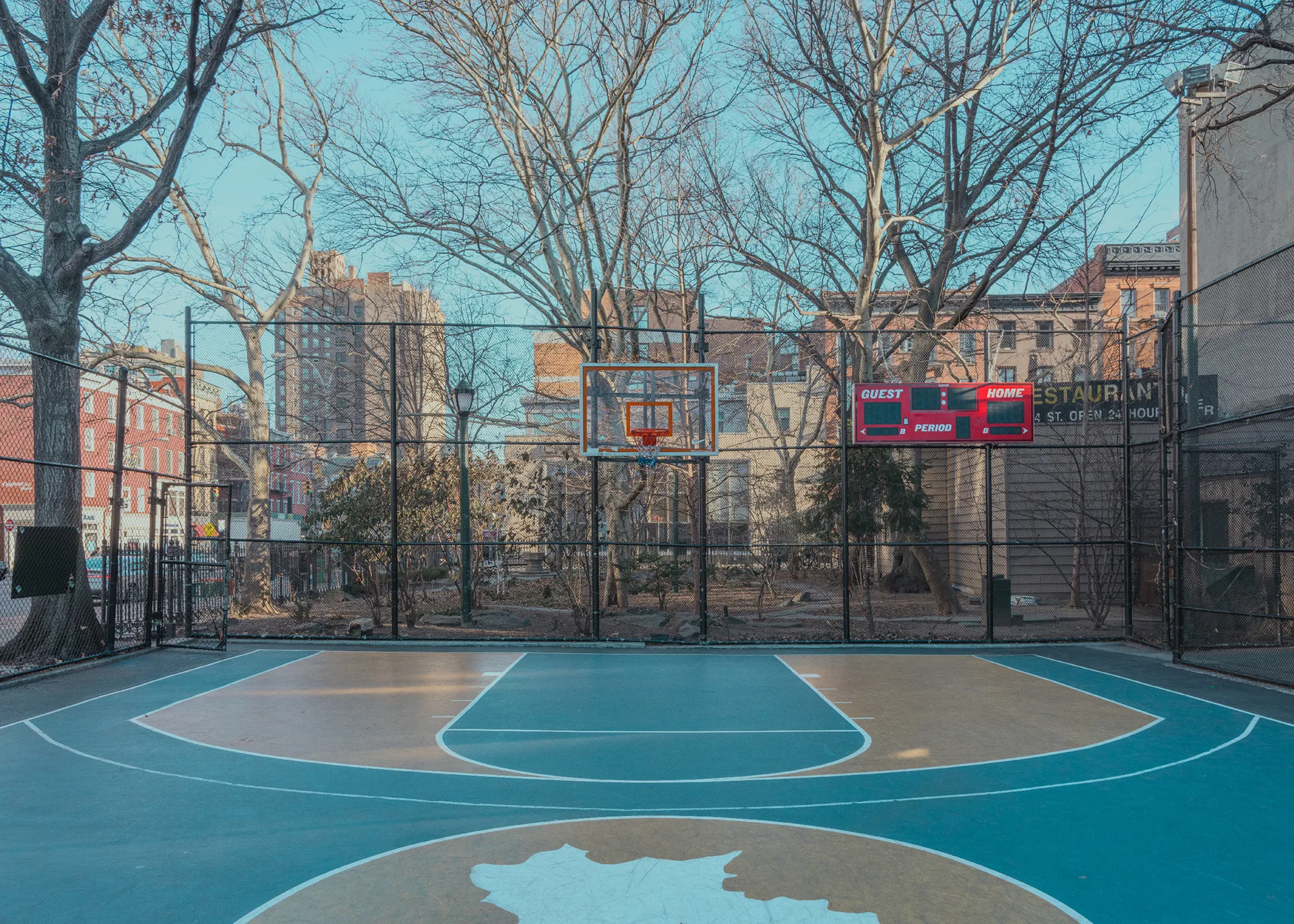 Quiet basketball court framed by trees and city buildings — limited edition fine art print by Ludwig Favre Quiet basketball court framed by trees and city buildings — limited edition fine art print by Ludwig Favre