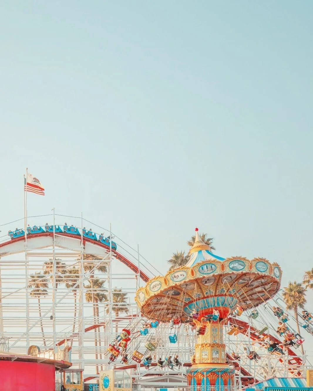 Coastal amusement park with a carousel and roller coaster, warm light — limited edition fine art print by Ludwig Favre Coastal amusement park with a carousel and roller coaster, warm light — limited edition fine art print by Ludwig Favre