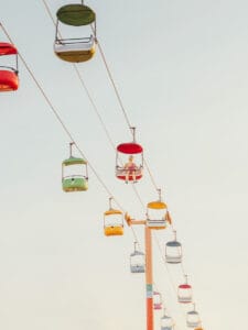 Colorful gondola cars suspended above Santa Cruz amusement park — limited edition fine art print by Ludwig Favre