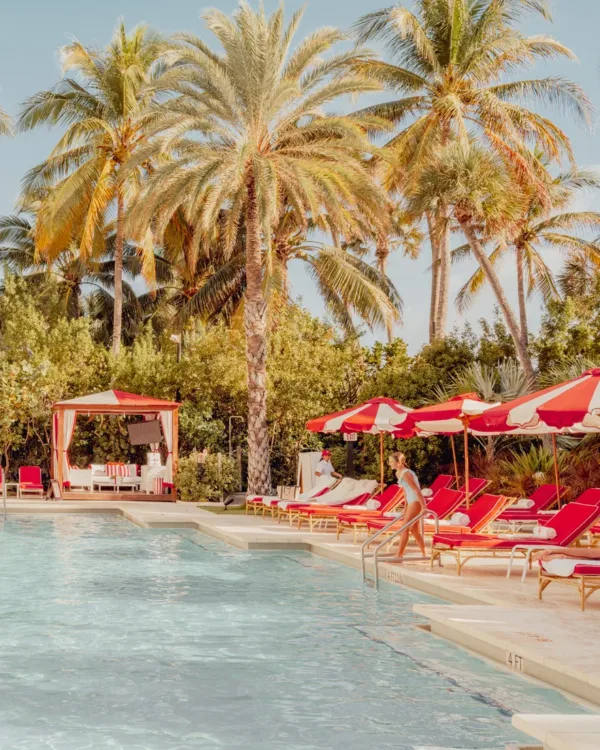 Turquoise Miami Beach swimming pool with red umbrellas and lounge chairs — limited edition fine art print by Ludwig Favre