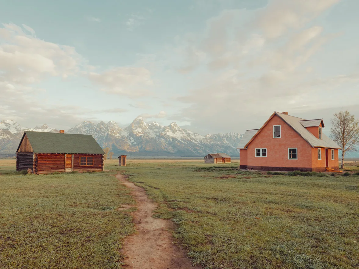 Two Wyoming homesteads under a soft sunset sky with the Grand Teton — limited edition fine art print by Ludwig Favre