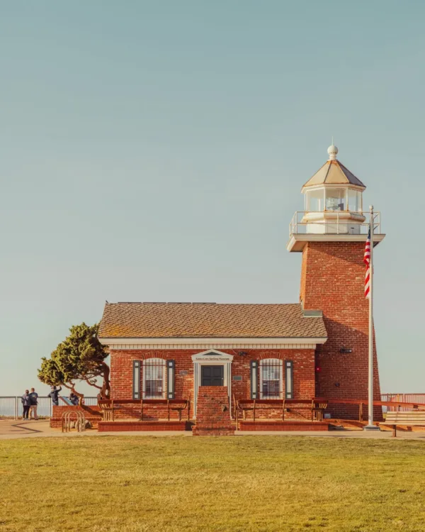 Santa Cruz lighthouse with a clear blue sky and green grass — limited edition fine art print by Ludwig Favre