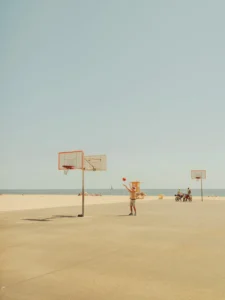 Figure on a sun-drenched Los Angeles beach with basketball hoops, fine art print by Ludwig Favre