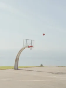 Basketball hoop on a concrete court with ocean view — limited edition fine art print by Ludwig Favre