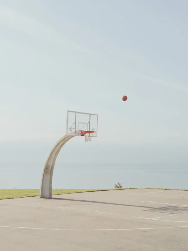 Basketball hoop on a concrete court with ocean view — limited edition fine art print by Ludwig Favre