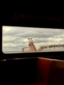 View of a Coney Island rollercoaster framed by a vehicle window — limited edition fine art print by Ludwig Favre