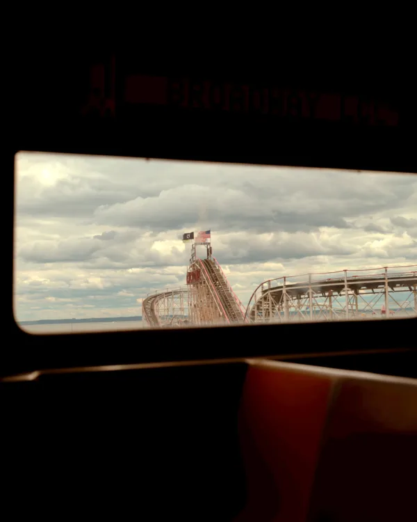 View of a Coney Island rollercoaster framed by a vehicle window — limited edition fine art print by Ludwig Favre