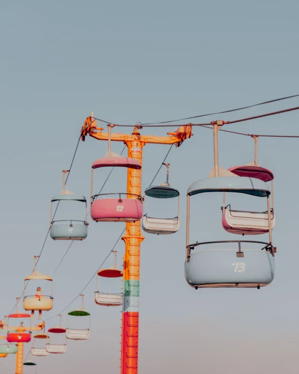 Colorful Santa Cruz amusement park with pastel rides and a clear sky — limited edition fine art print by Ludwig Favre