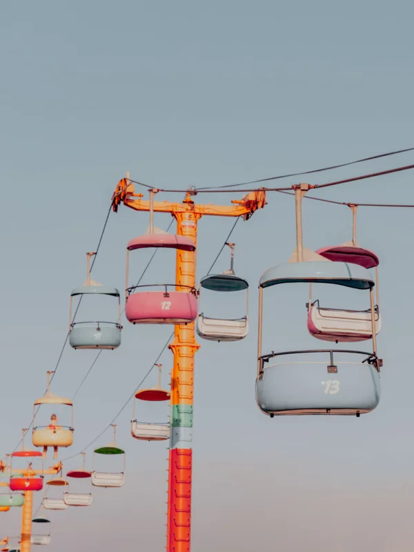Pastel gondolas suspended above Santa Cruz amusement park with a clear sky — limited edition fine art print by Ludwig Favre