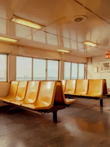 Empty orange seats and a distant skyline on the Staten Island ferry — limited edition fine art print by Ludwig Favre