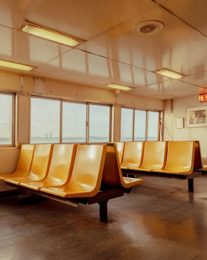 New York Fine Art Prints Empty orange seats and a distant skyline on the Staten Island ferry — limited edition fine art print by Ludwig Favre