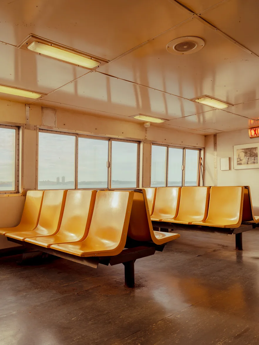 New York Fine Art Prints Empty orange seats and a distant skyline on the Staten Island ferry — limited edition fine art print by Ludwig Favre