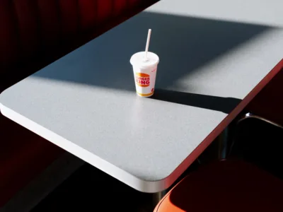 Red chair and Burger King cup on a grey table — limited edition fine art print by Ludwig Favre