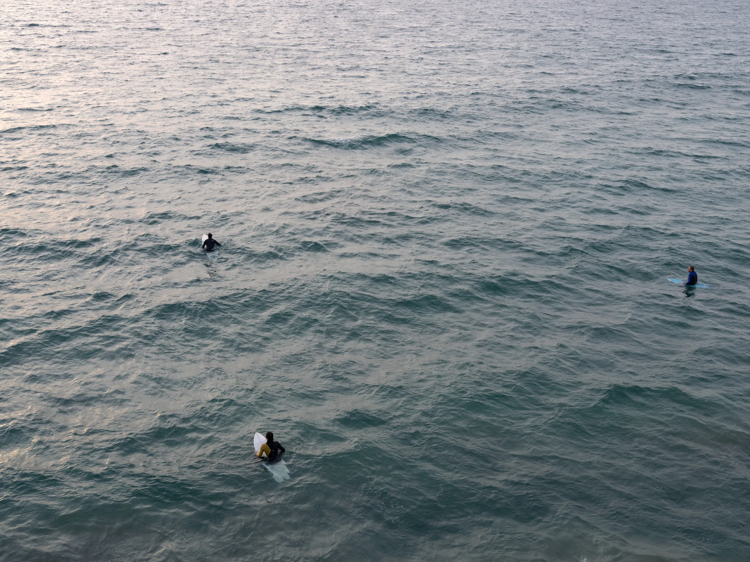 Surfers on a calm ocean, captured in a quiet scene — limited edition fine art print by Ludwig Favre