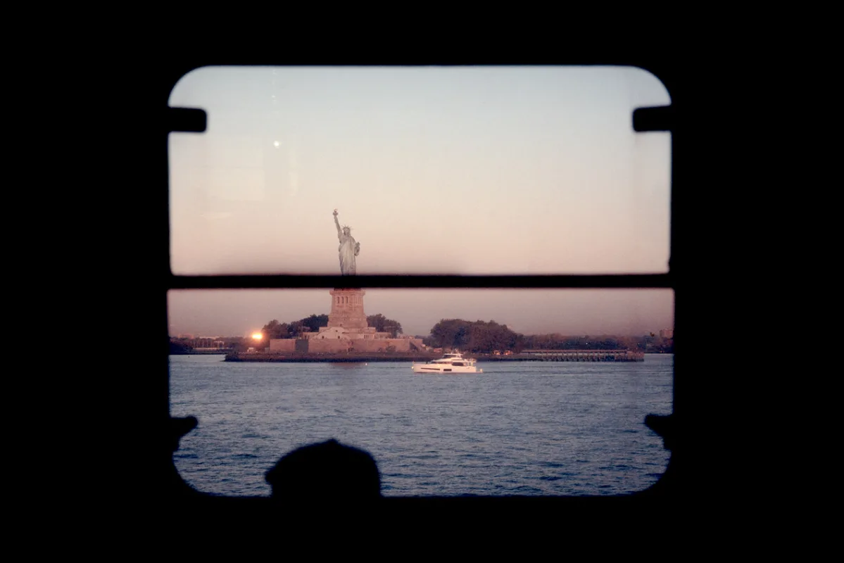 Statue of Liberty viewed through a window, quiet dusk — limited edition fine art print by Ludwig Favre
