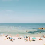Striped umbrellas on a sandy beach at Costa del Sol under clear blue sky, limited edition fine art print by Ludwig Favre