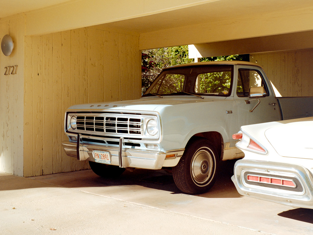 A mint-condition classic car, possibly a 1970s Dodge pickup, in an underground garage illuminated by warm afternoon light, limited edition fine art print by Ludwig Favre