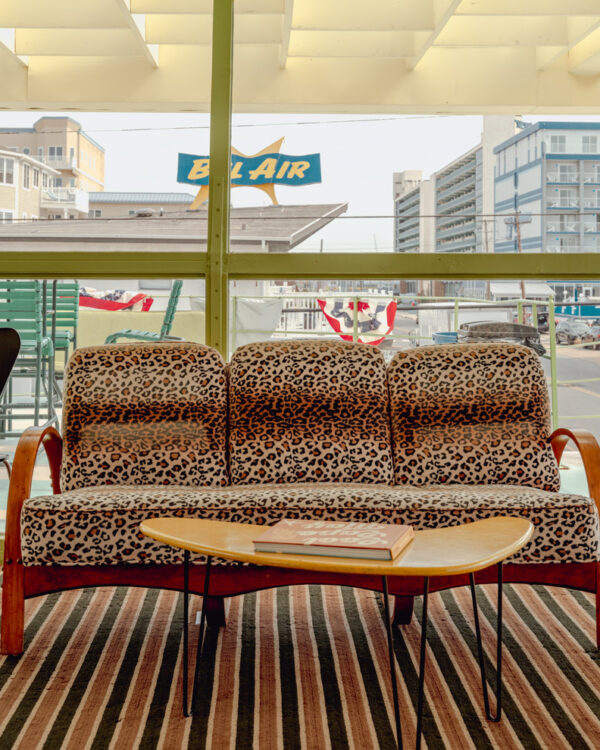 Leopard print sofa in a Wildwood motel lounge facing the Bel Air sign, limited edition fine art photograph by Ludwig Favre