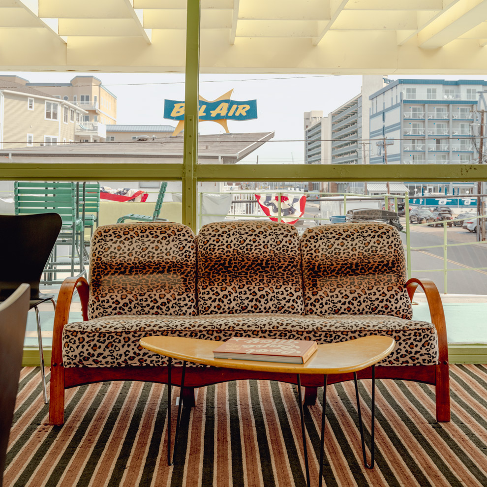 Leopard print sofa in a Wildwood motel lounge facing the Bel Air sign, limited edition fine art photograph by Ludwig Favre