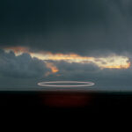 A bright searchlight trail against a dramatic twilight sky over Iceland's volcanic landscape, limited edition fine art print by Ludwig Favre