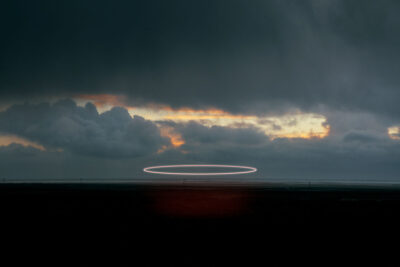 A bright searchlight trail against a dramatic twilight sky over Iceland's volcanic landscape, limited edition fine art print by Ludwig Favre