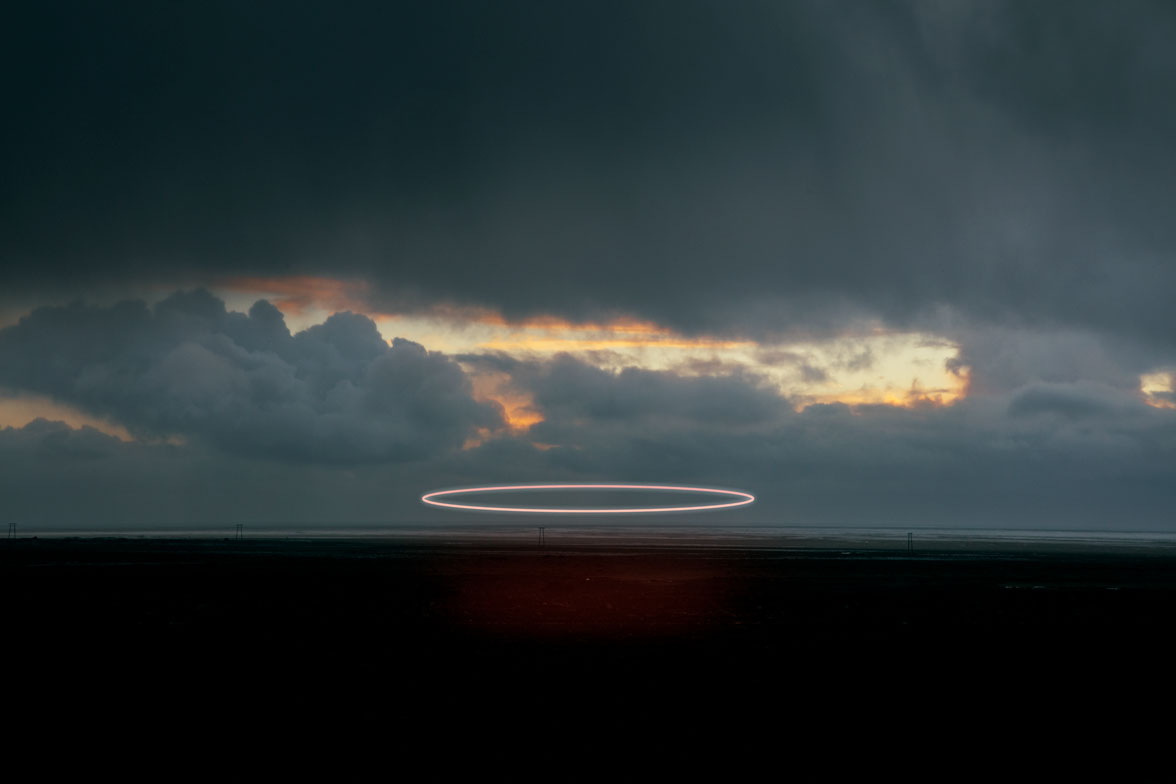 A bright searchlight trail against a dramatic twilight sky over Iceland's volcanic landscape, limited edition fine art print by Ludwig Favre