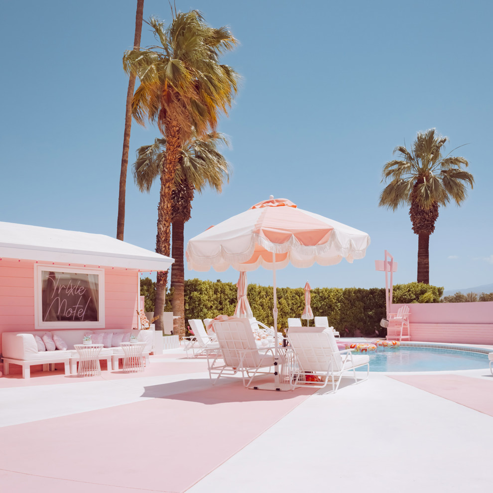 Pink motel pool deck with a striped umbrella and palm trees, Palm Springs, limited edition fine art photograph by Ludwig Favre