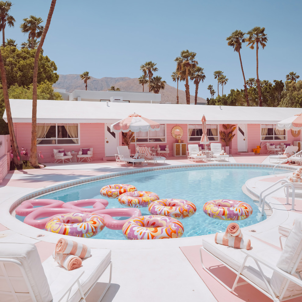 Pink motel pool with donut floats and palm trees, Palm Springs, limited edition fine art photograph by Ludwig Favre