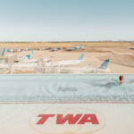 Swimmer in the TWA Hotel rooftop pool above the JFK runways, limited edition fine art photograph by Ludwig Favre