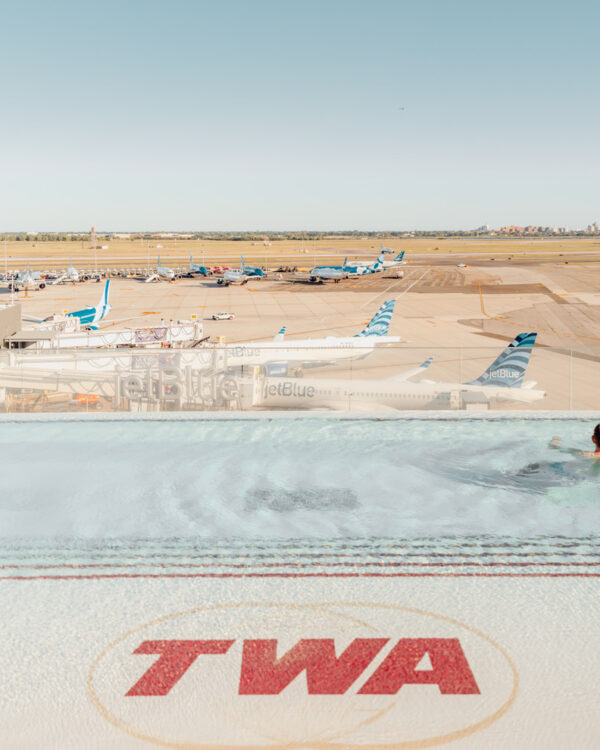 Swimmer in the TWA Hotel rooftop pool above the JFK runways, limited edition fine art photograph by Ludwig Favre