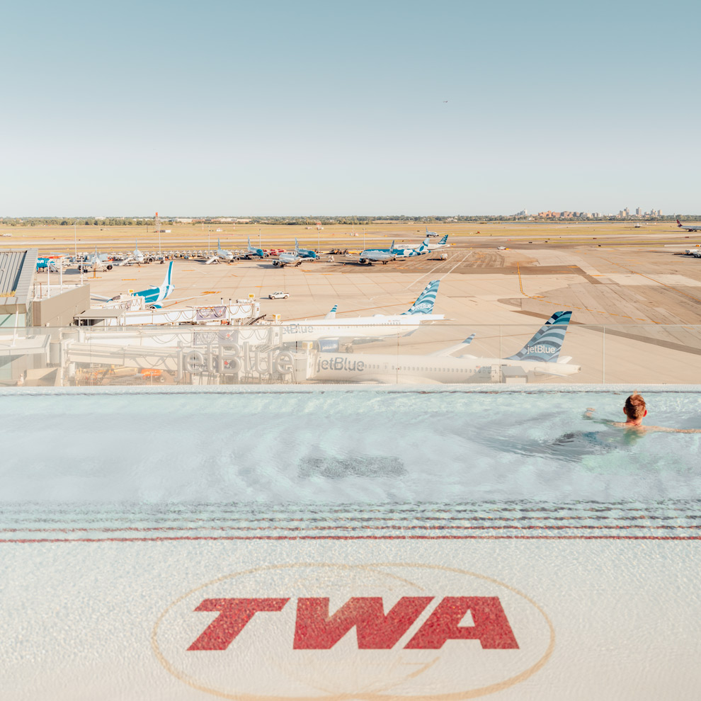 Swimmer in the TWA Hotel rooftop pool above the JFK runways, limited edition fine art photograph by Ludwig Favre