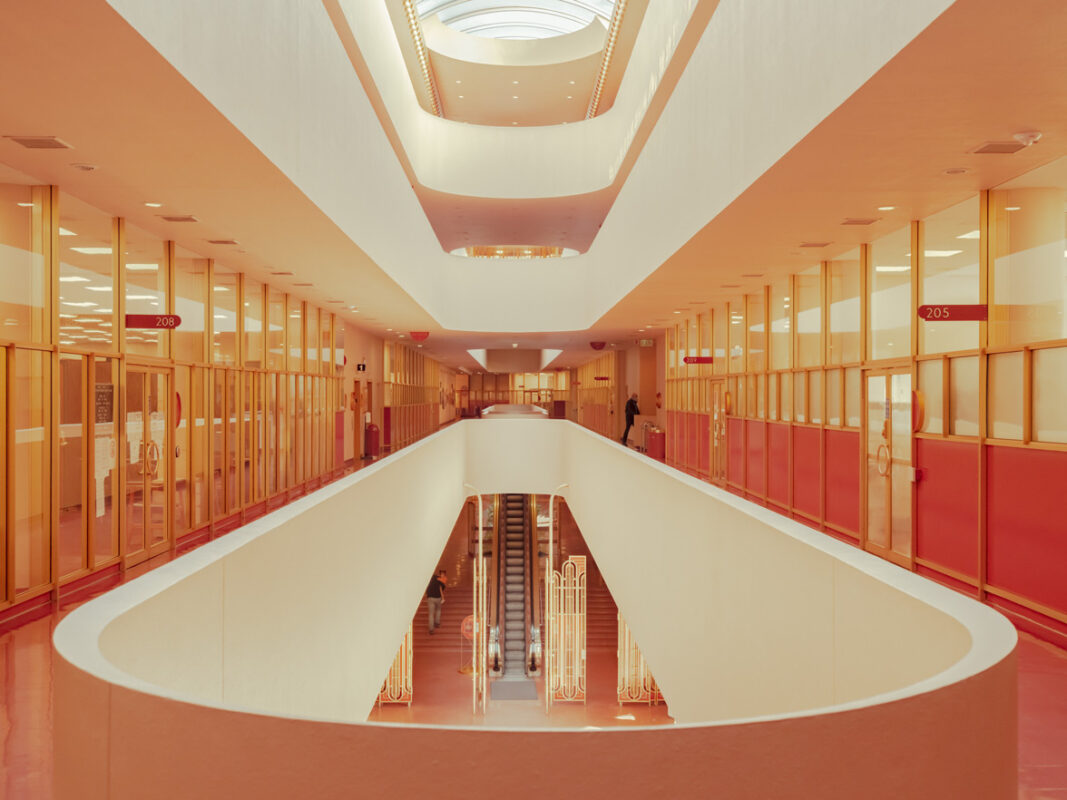 Symmetrical view of an orange and cream staircase under a bright oval skylight in San Francisco, fine art print by Ludwig Favre