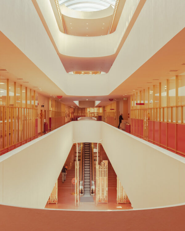 Symmetrical view of an orange and cream staircase under a bright oval skylight in San Francisco, fine art print by Ludwig Favre